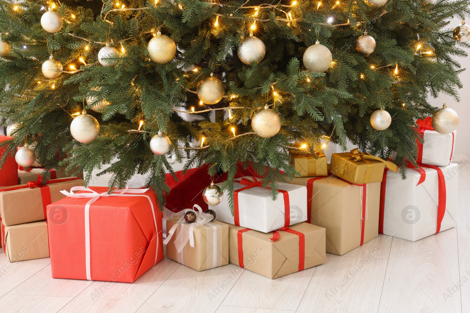 Photo of Beautiful Christmas tree with festive lights and gifts indoors