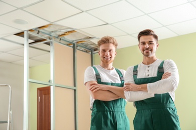 Construction workers in uniforms indoors. Home repair service