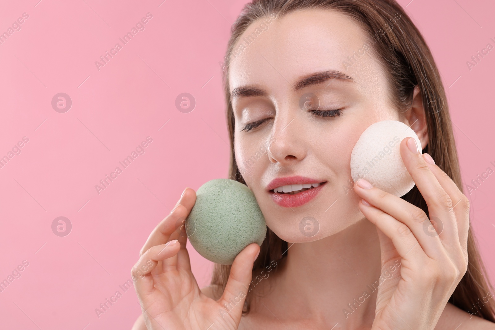 Photo of Happy young woman with face sponges on pink background. Space for text