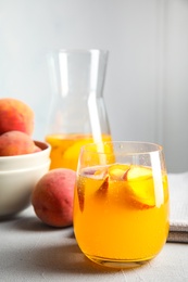 Photo of Tasty peach cocktail on table. Refreshing drink