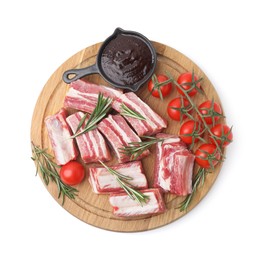 Photo of Cut raw pork ribs with rosemary, tomatoes and sauce isolated on white, top view