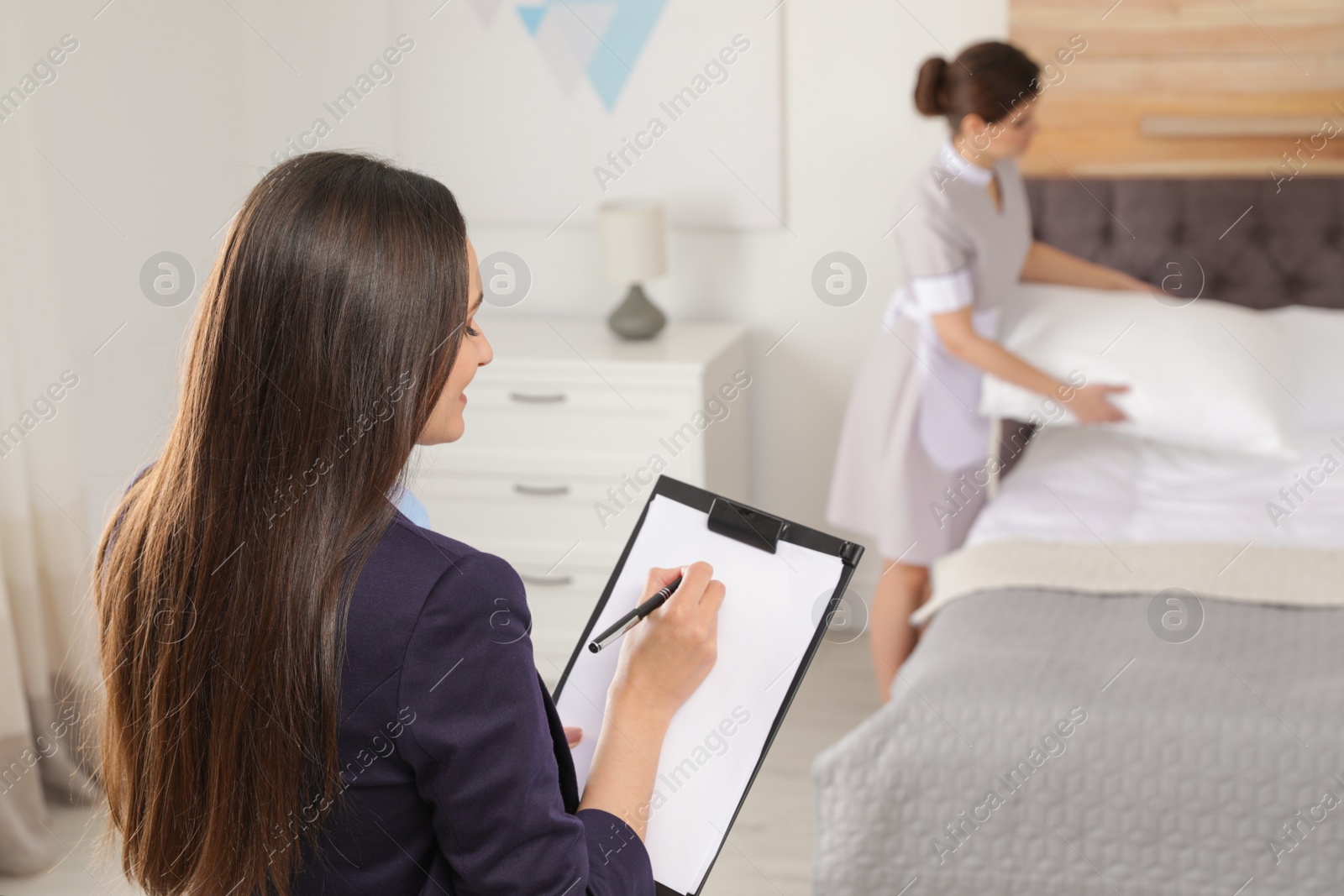 Photo of Housekeeping manager checking maid work in hotel room