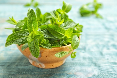 Photo of Bowl with fresh aromatic mint on table