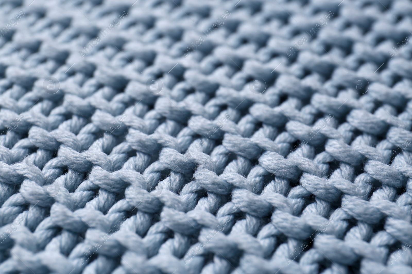 Photo of Beautiful light blue knitted fabric as background, closeup