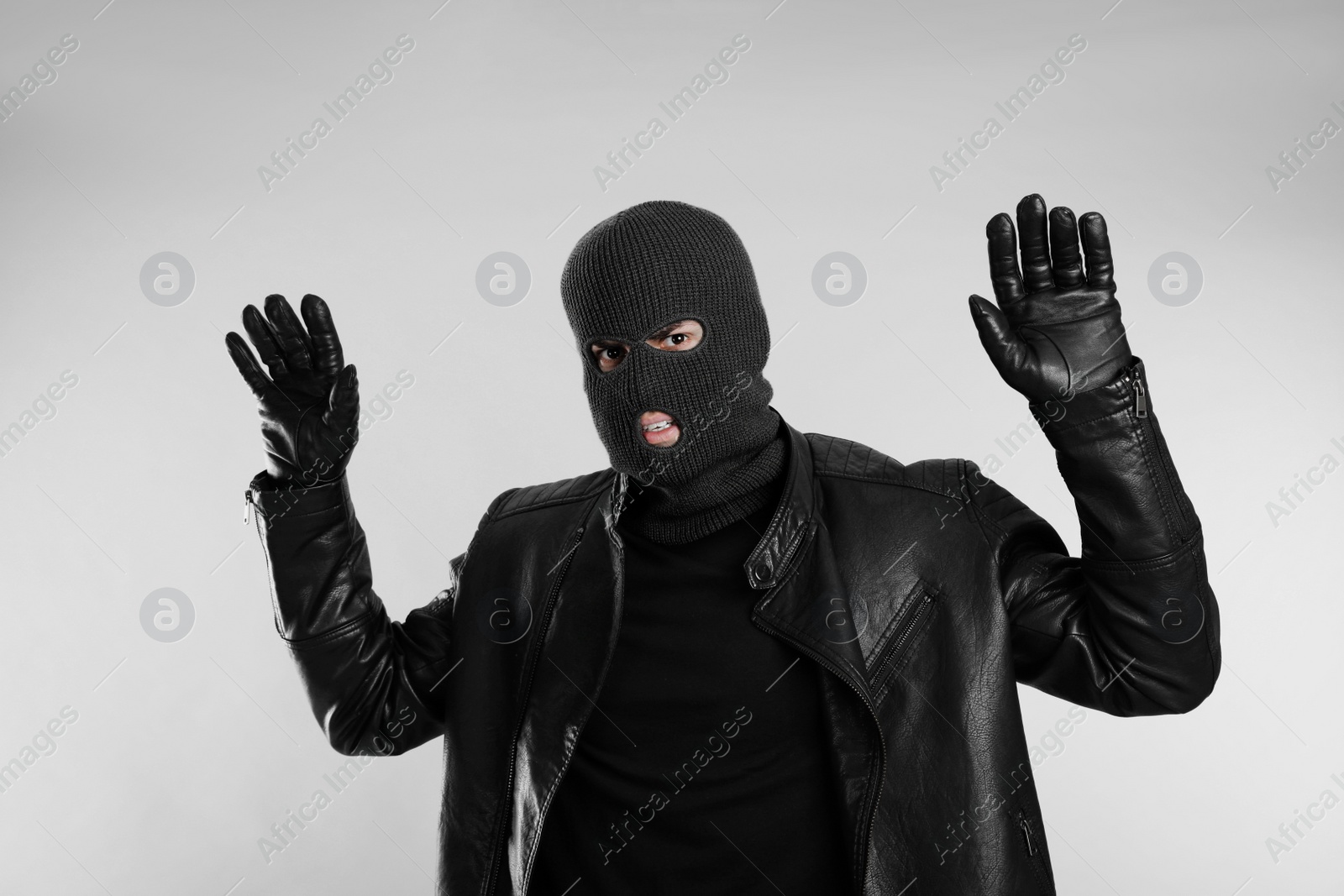 Photo of Man wearing knitted balaclava on light grey background