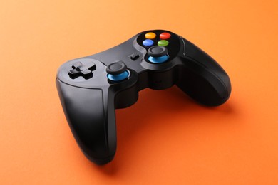 One wireless game controller on orange background