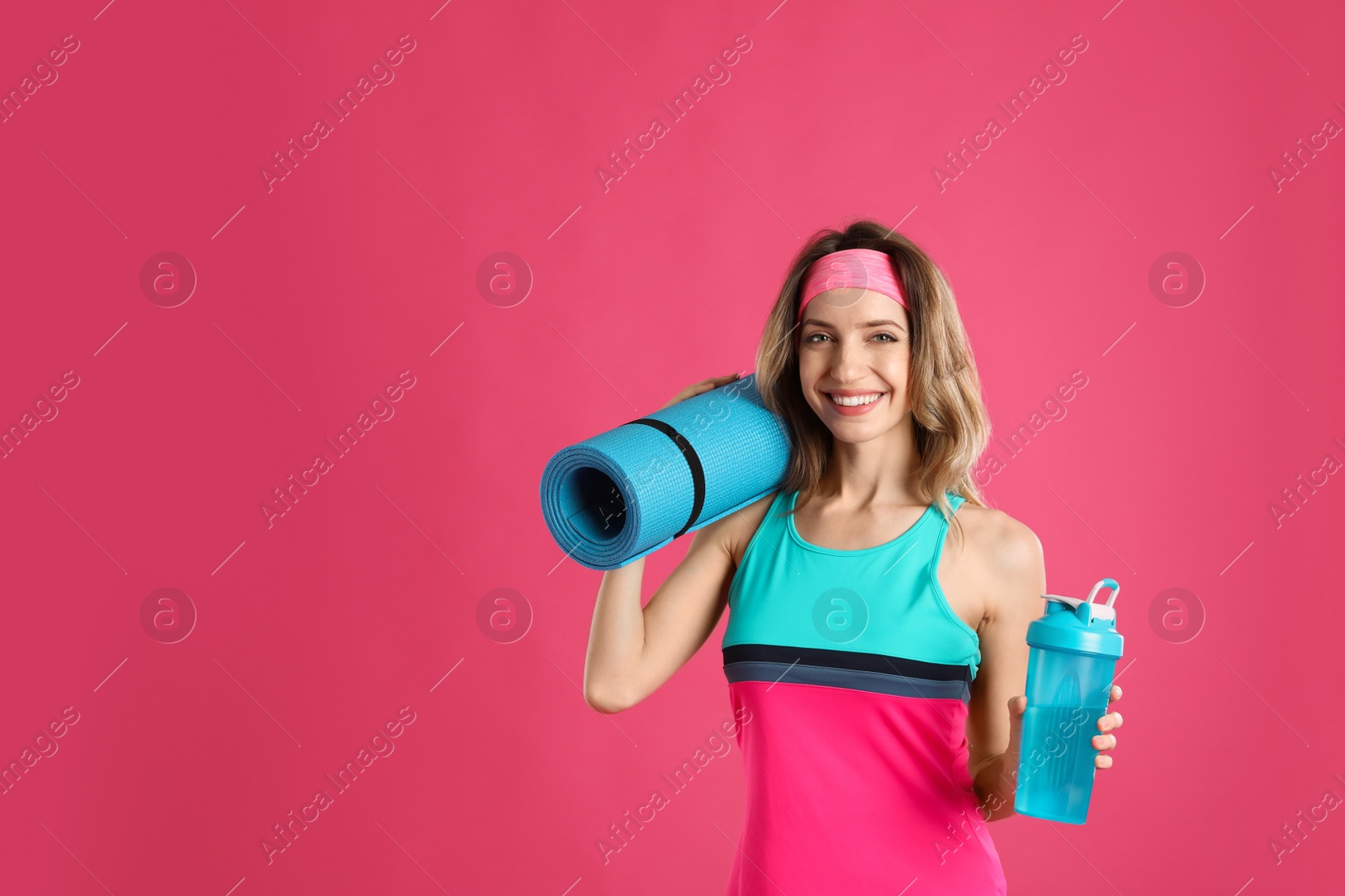 Photo of Beautiful woman with yoga mat and shaker on pink background. Space for text