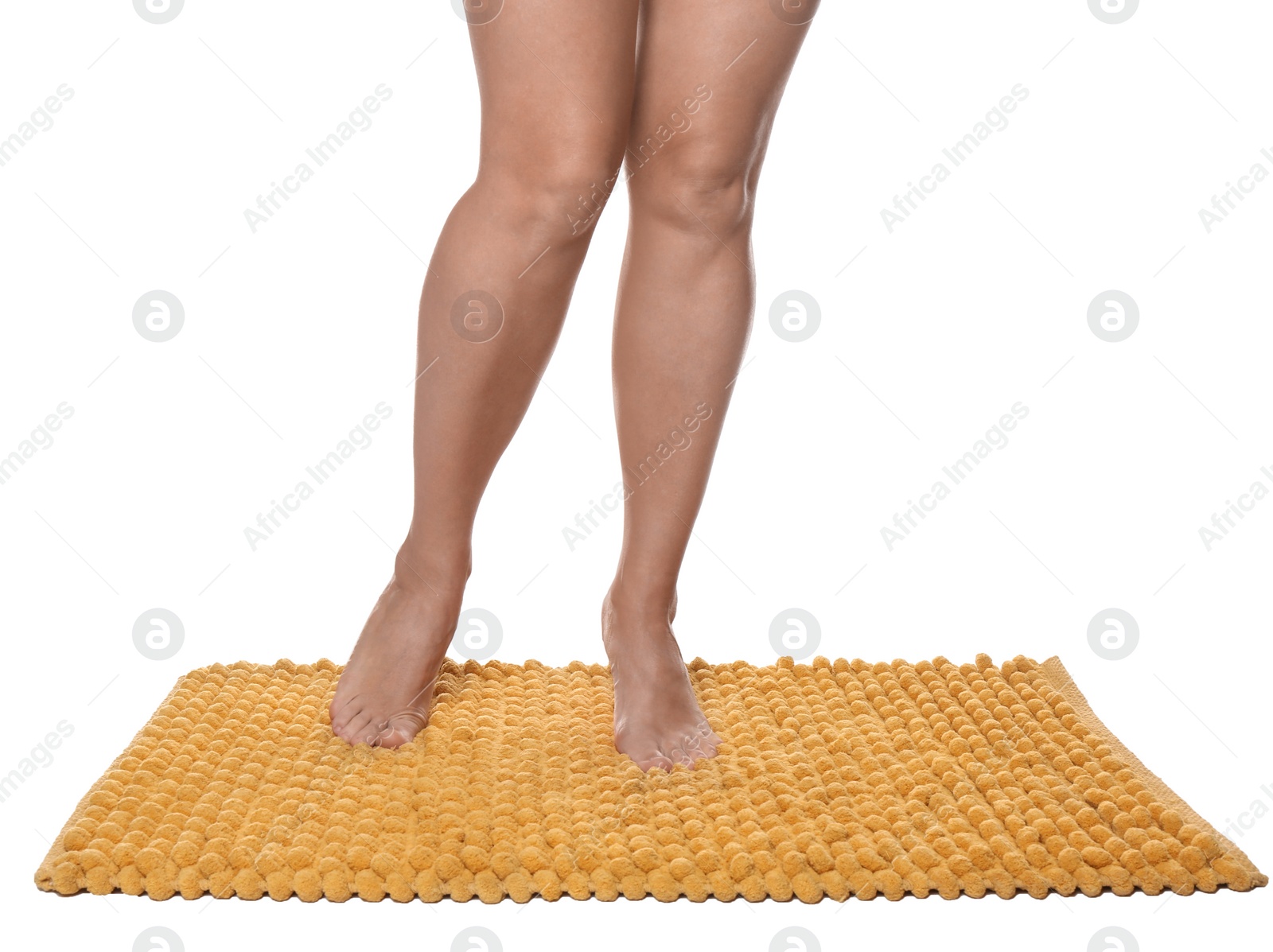 Photo of Woman standing on soft orange bath mat against white background, closeup