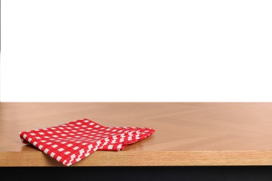 Photo of Checkered tablecloth on wooden table against white background