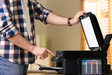 Photo of Man using modern multifunction printer in office, closeup