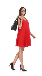 Photo of Young woman wearing stylish red dress with elegant bag on white background