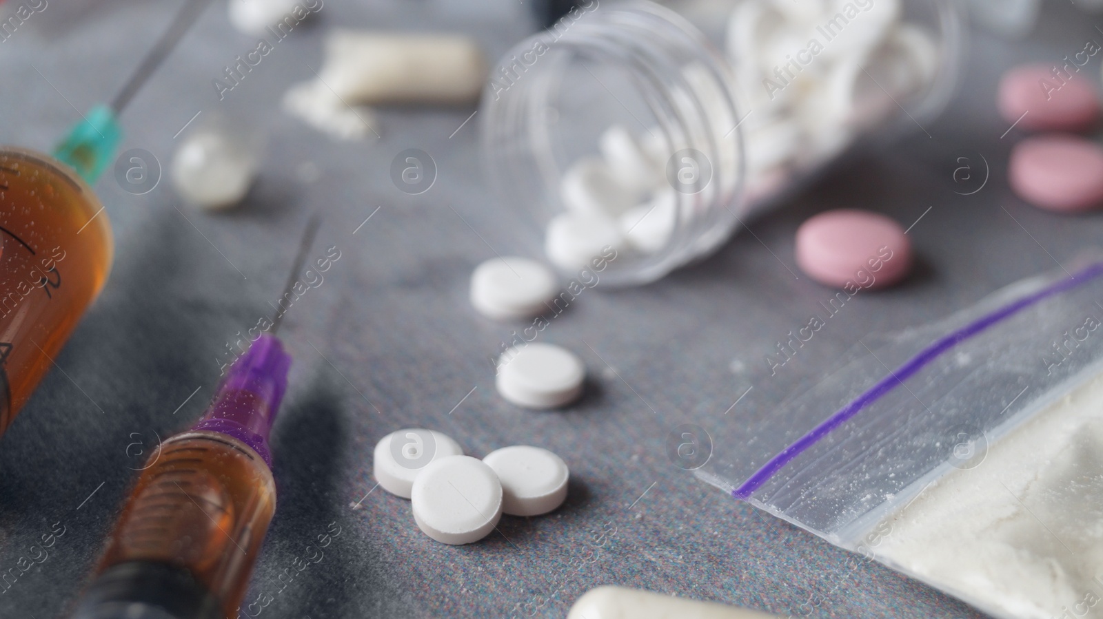 Photo of Different hard drugs on grey table, closeup