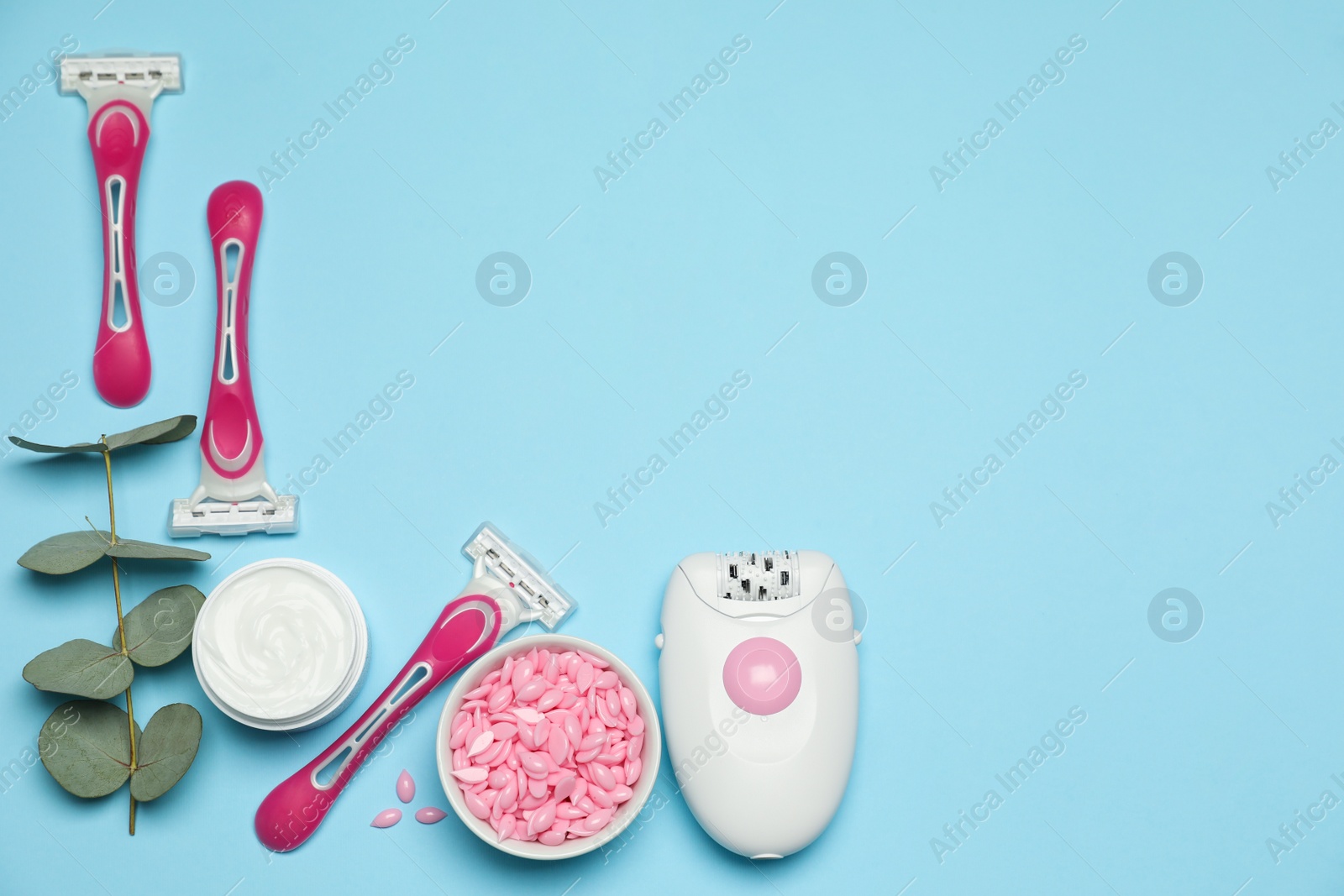 Photo of Flat lay composition with epilator and other hair removal products on light blue background. Space for text