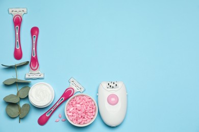 Photo of Flat lay composition with epilator and other hair removal products on light blue background. Space for text