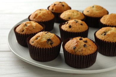 Photo of Delicious freshly baked muffins with chocolate chips on table, closeup