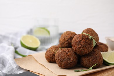 Photo of Delicious falafel balls, arugula and lime on table, closeup. Space for text