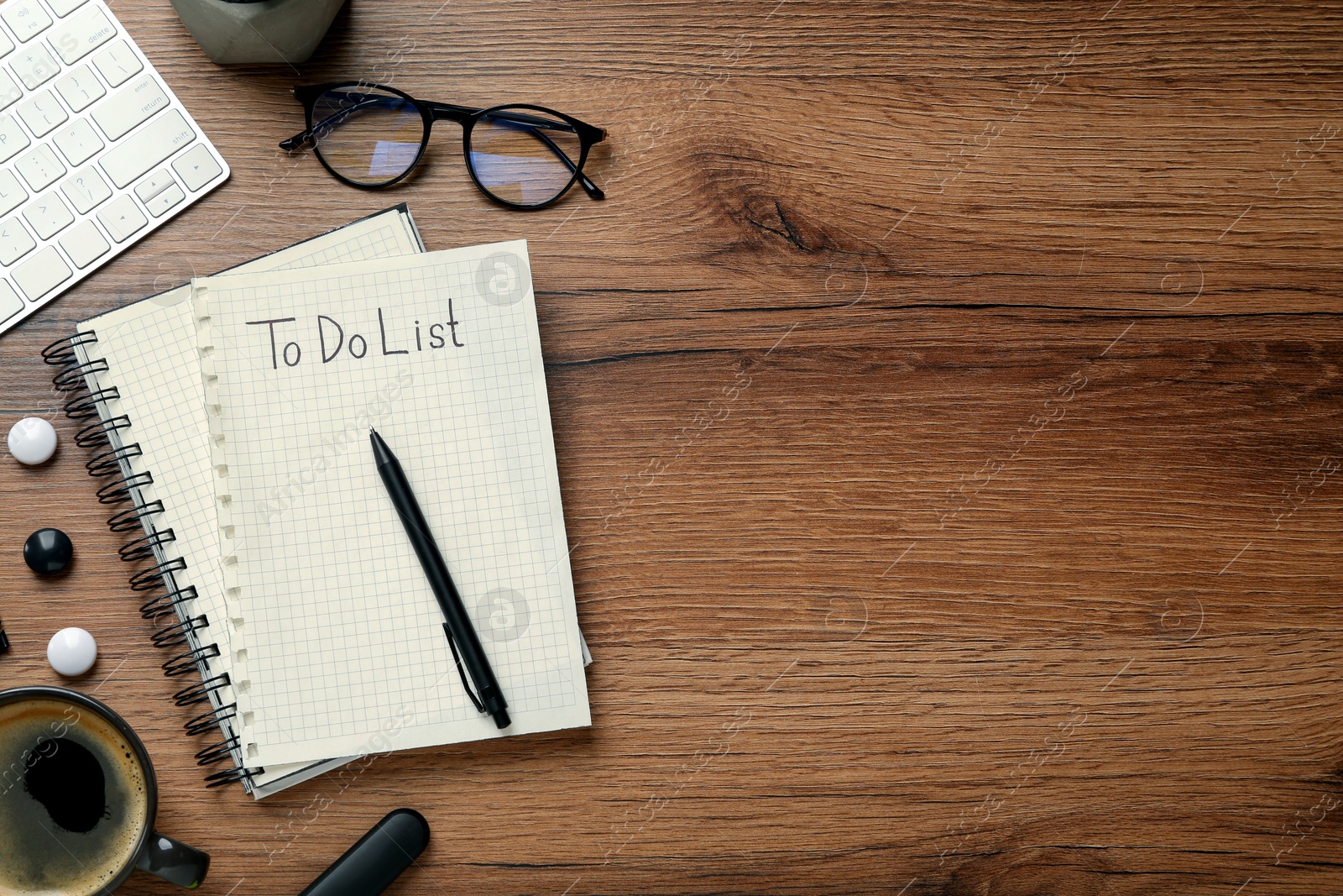 Photo of Flat lay composition with unfilled To Do list, cup of coffee and glasses on wooden table, space for text