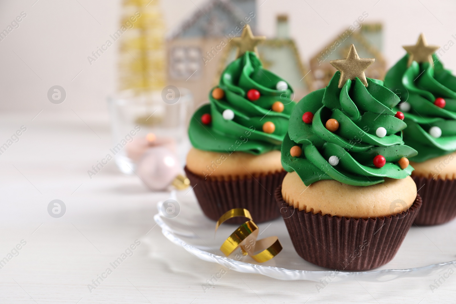 Photo of Christmas tree shaped cupcakes on white table. Space for text