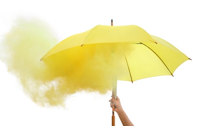 Woman holding umbrella with yellow smoke bomb outdoors, closeup