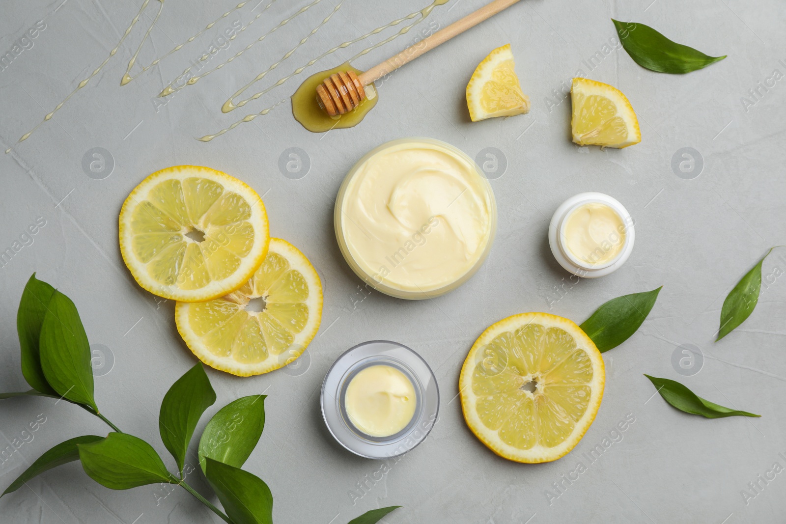 Photo of Flat lay composition with hand cream jars on gray background