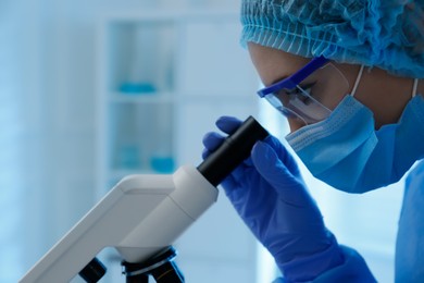 Photo of Scientist working with microscope in laboratory, closeup. Medical research