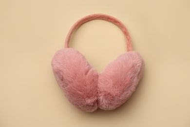 Photo of Stylish winter earmuffs on beige background, top view