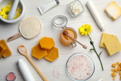 Photo of Flat lay composition with beeswax and cosmetic products on white wooden table