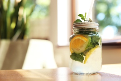 Photo of Refreshing natural lemonade with mint in mason jar on table. Detox drink