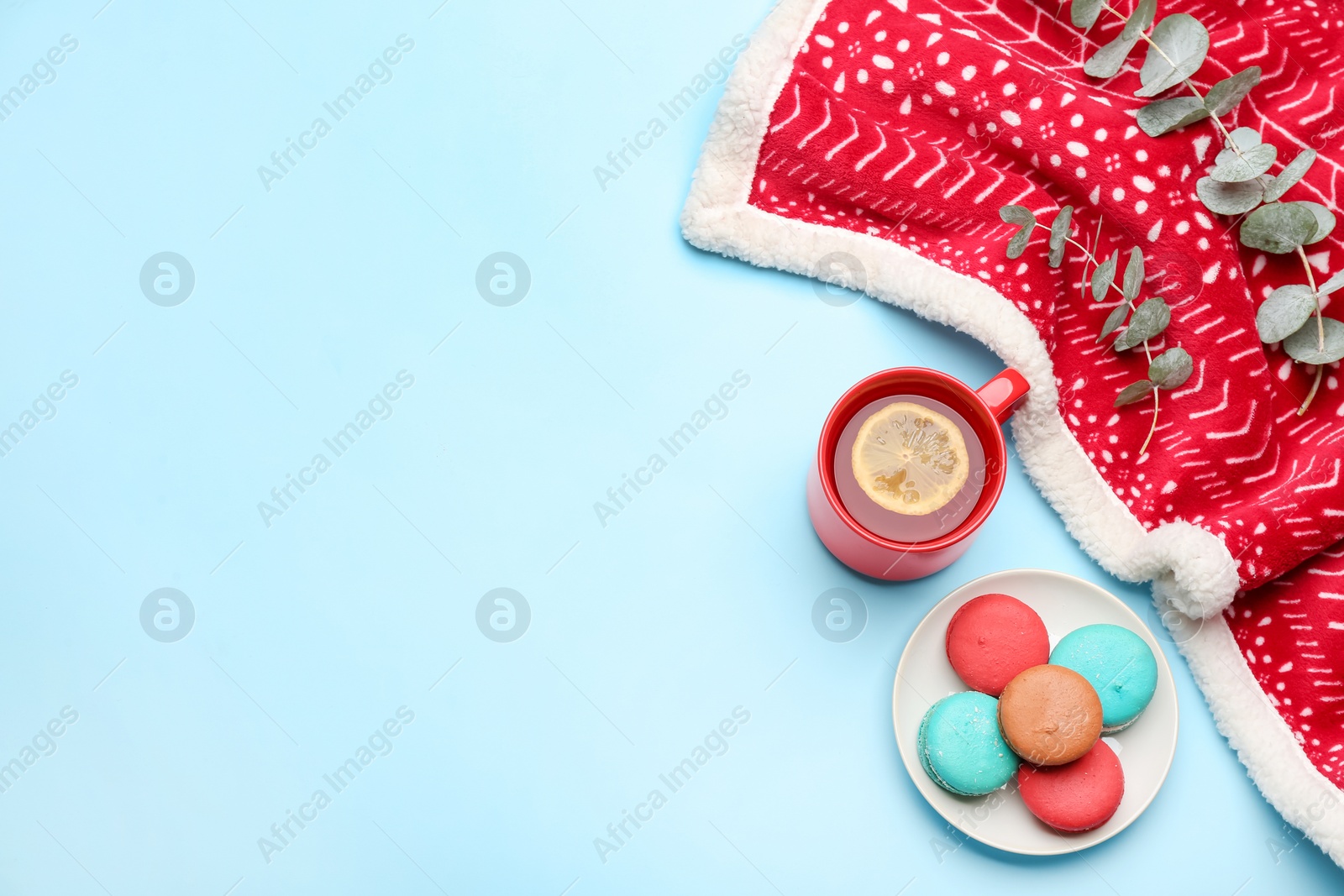 Photo of Flat lay composition with tea and warm plaid on light blue background, space for text