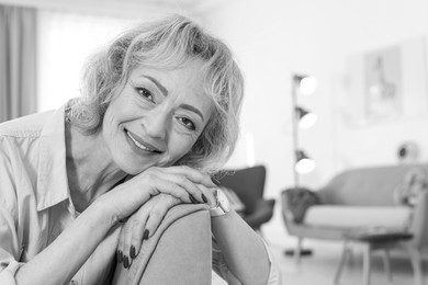 Portrait of mature woman in living room. Black and white photography
