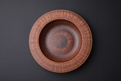 Photo of Ceramic bowl on black background, top view
