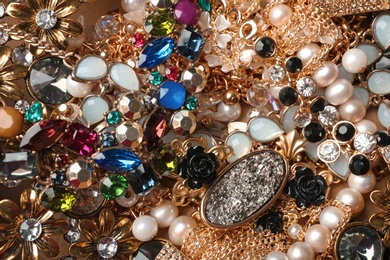 Photo of Different elegant jewelry as background, top view