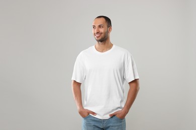 Man wearing white t-shirt on gray background