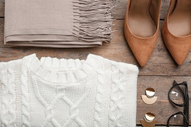 Flat lay composition with warm clothes on wooden background