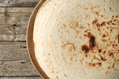 Stack of tasty homemade tortillas on wooden table, top view