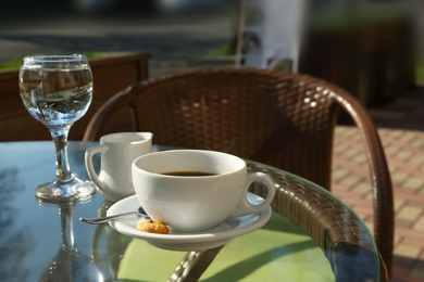 Photo of Cup of fresh aromatic coffee at table in cafe