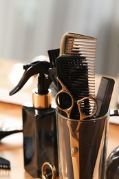 Photo of Set of hairdresser tools on table in salon, closeup