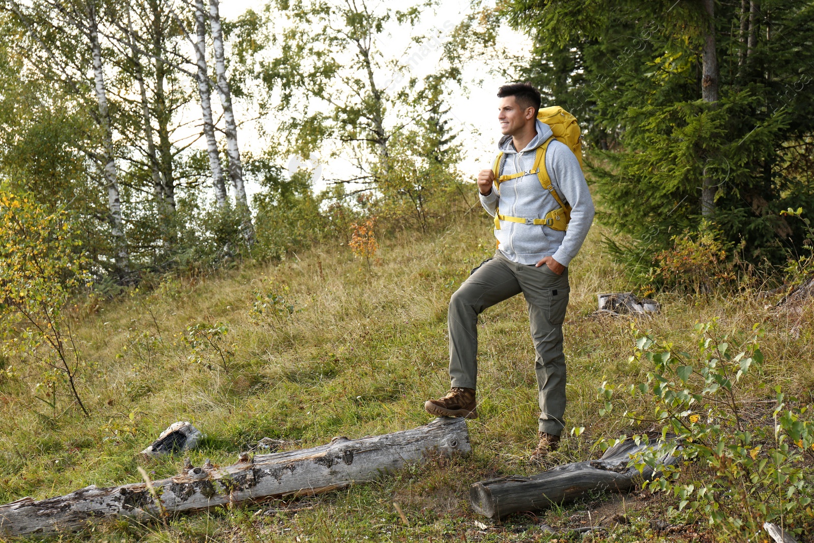 Photo of Man with yellow backpack outdoors, space for text. Tourism equipment