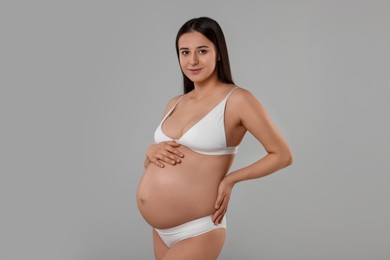 Photo of Beautiful pregnant woman in stylish comfortable underwear on grey background