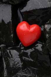 Photo of Red decorative heart on stones and water, top view