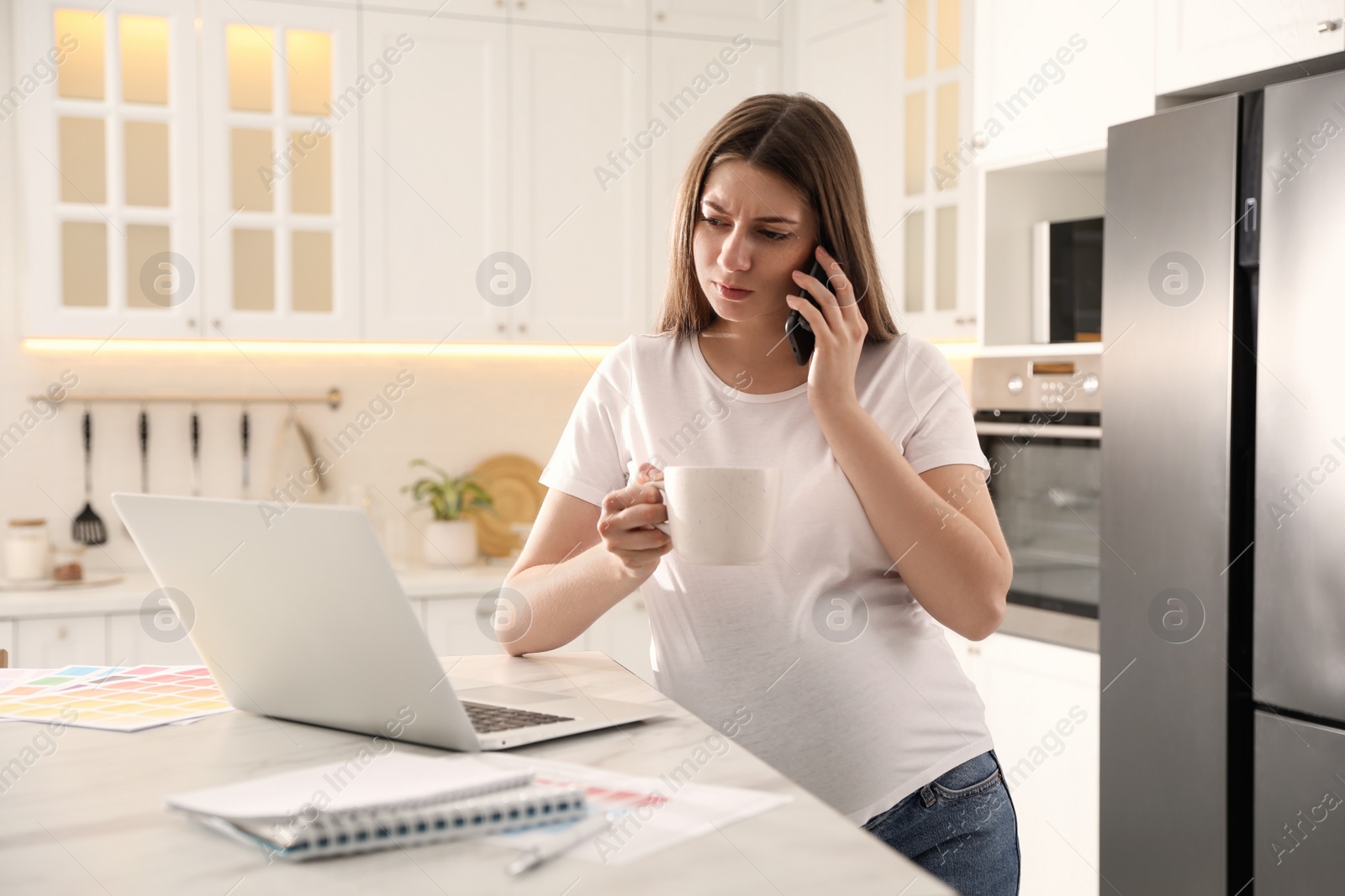 Photo of Pregnant woman working in kitchen at home. Maternity leave