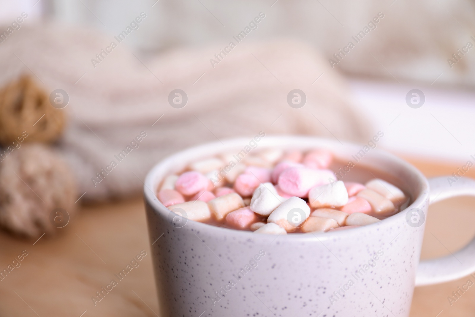 Photo of Cup of aromatic cacao with marshmallows on blurred background, closeup. Space for text