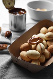 Delicious walnut shaped cookies with condensed milk on table