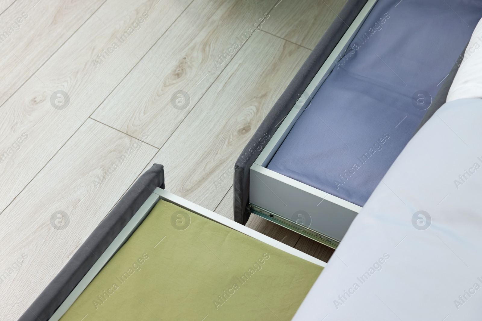 Photo of Storage drawers with bedding under comfortable bed in room