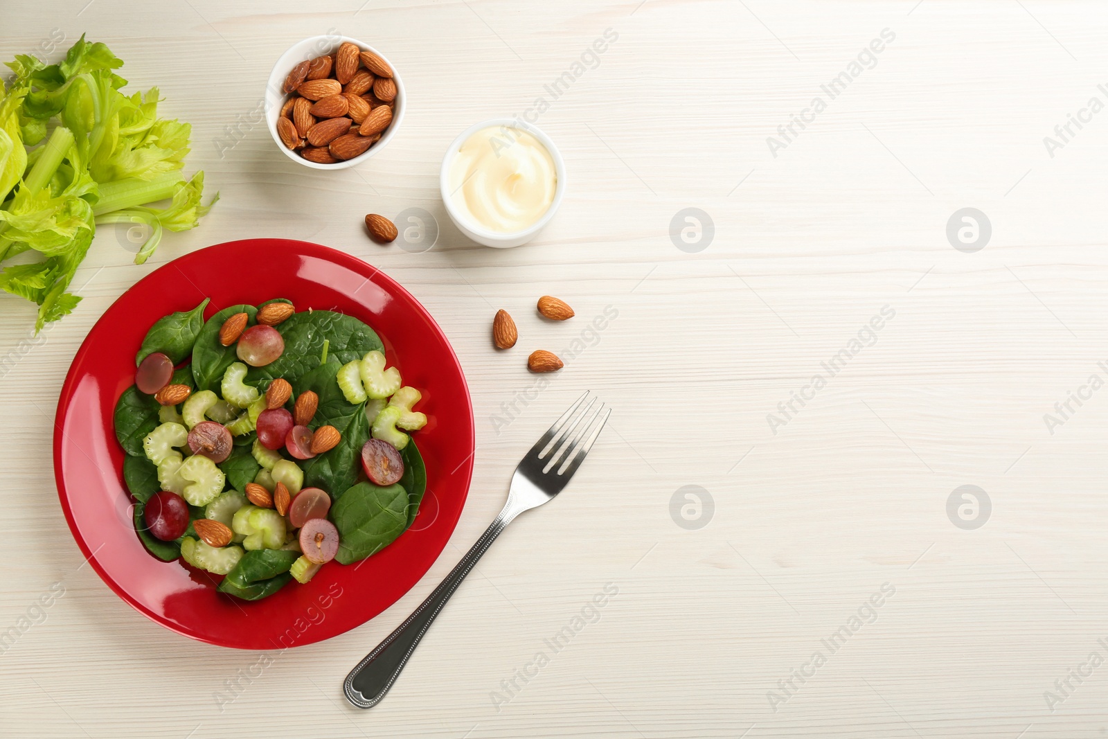 Photo of Delicious fresh celery salad served on white wooden table, flat lay. Space for text