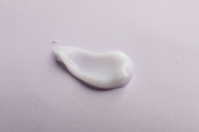 Photo of Sample of cream on pink surface, top view