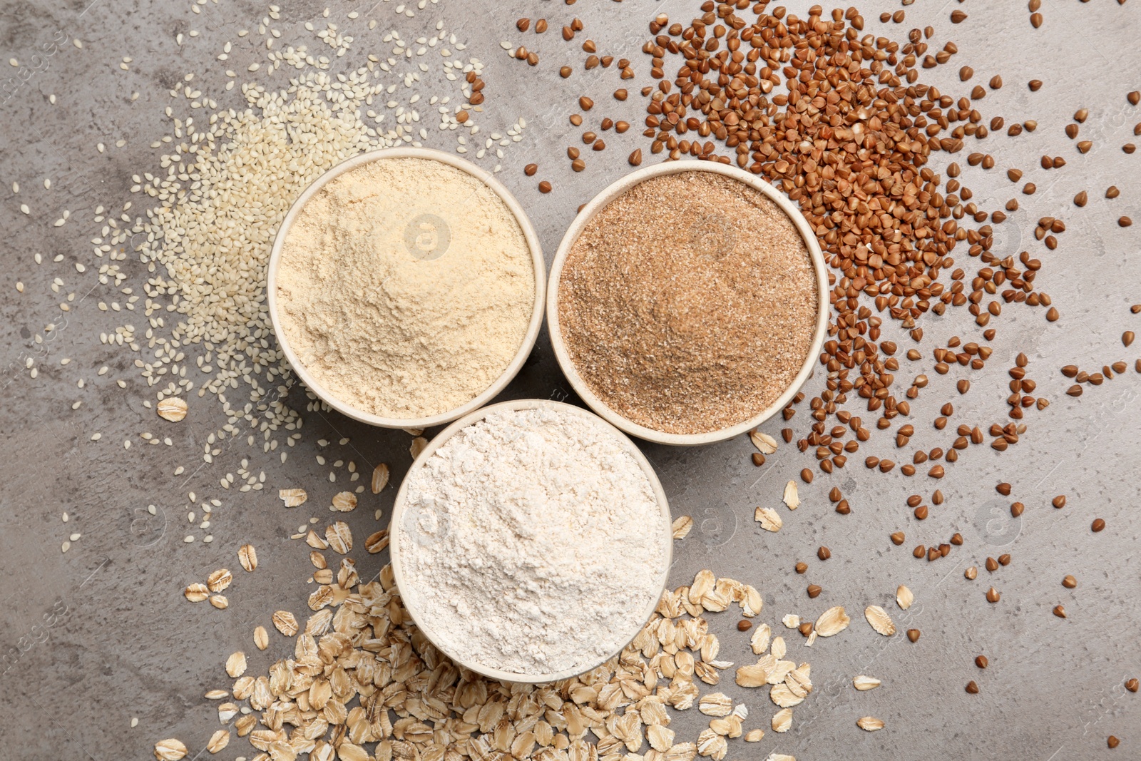 Photo of Flat lay composition with different types of flour on grey background