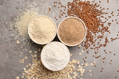 Flat lay composition with different types of flour on grey background