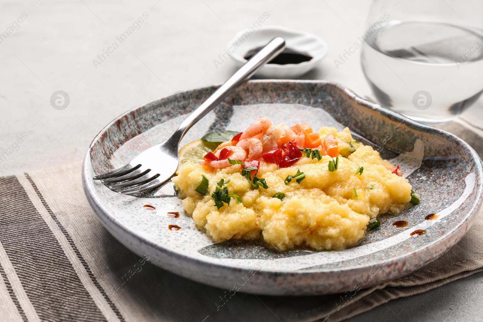 Photo of Plate with tasty shrimps and grits on table