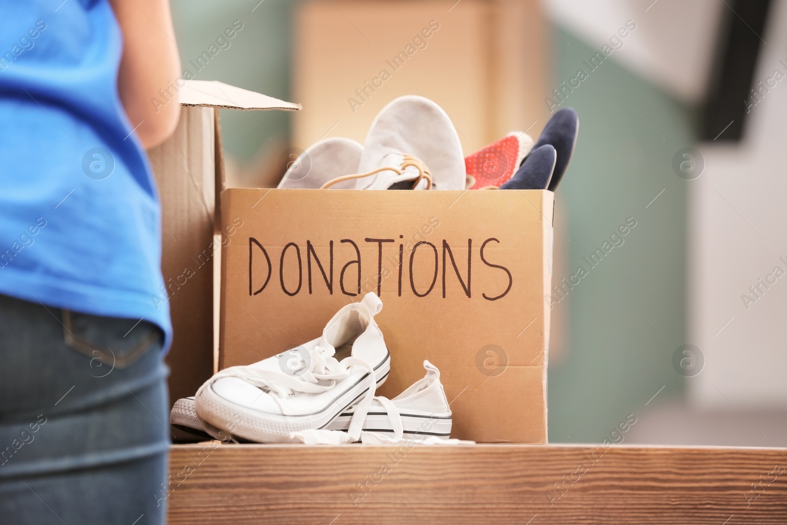 Photo of Donation box with shoes on table indoors